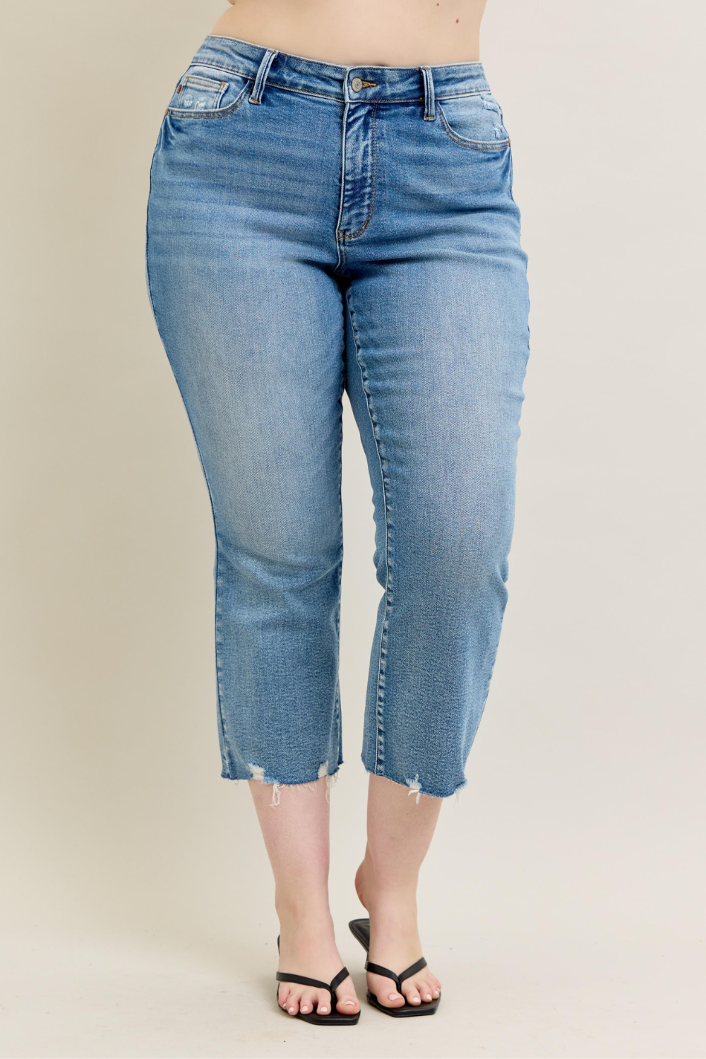 Front view of Nell medium-rise Judy Blue kick flare jeans in vintage wash with destroyed hem, modeled in plus-size fit.