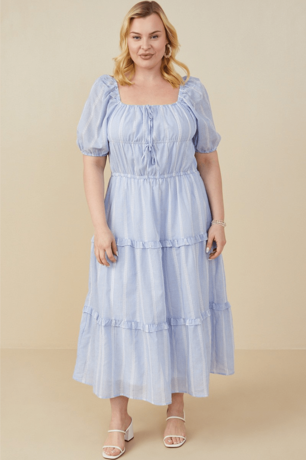 Plus-size model wearing the Iliana blue crochet lace midi dress with bow detail and square neckline – available at Ari + Ava